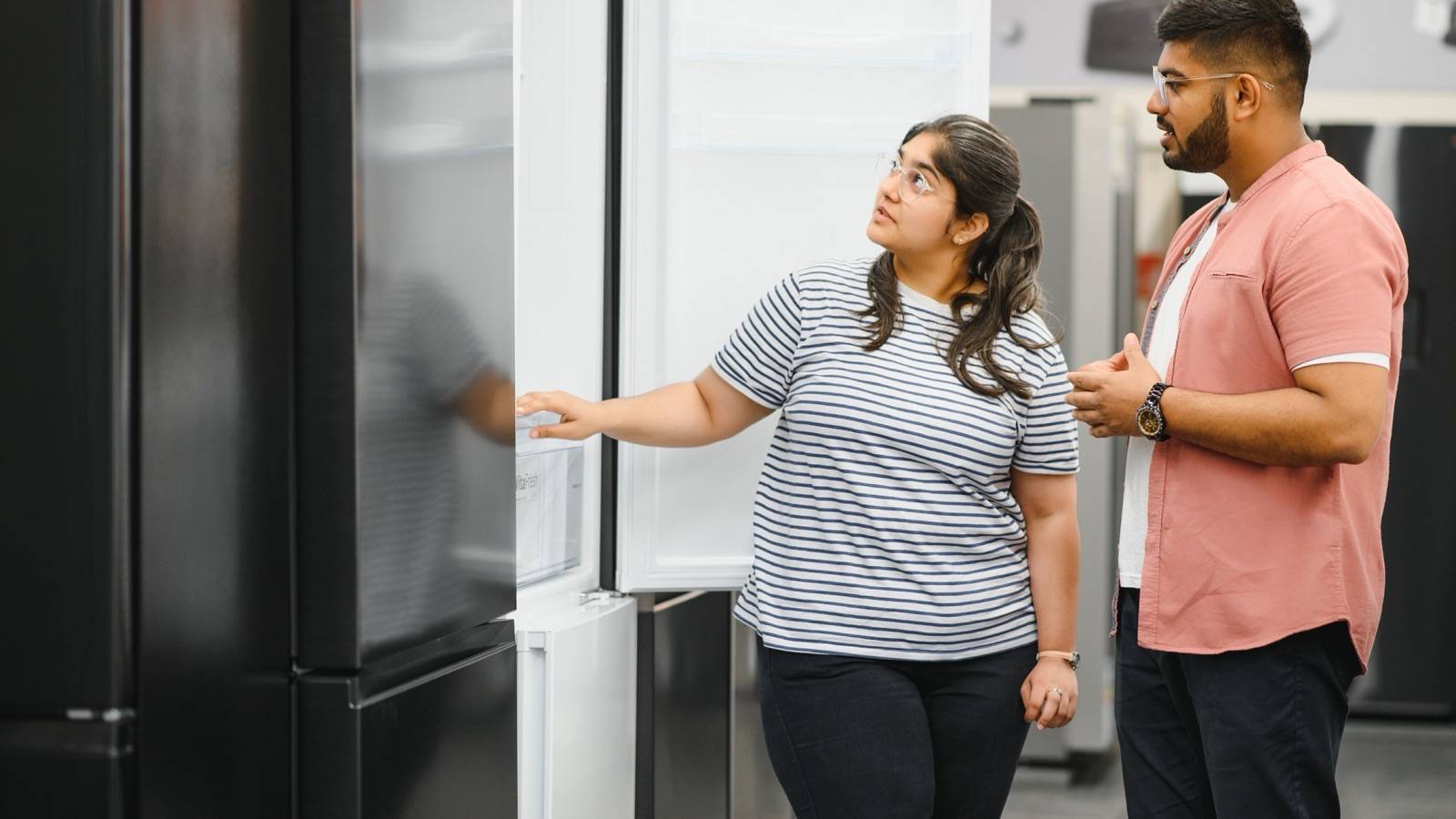 Couple looking at a fridge in an electronics shop